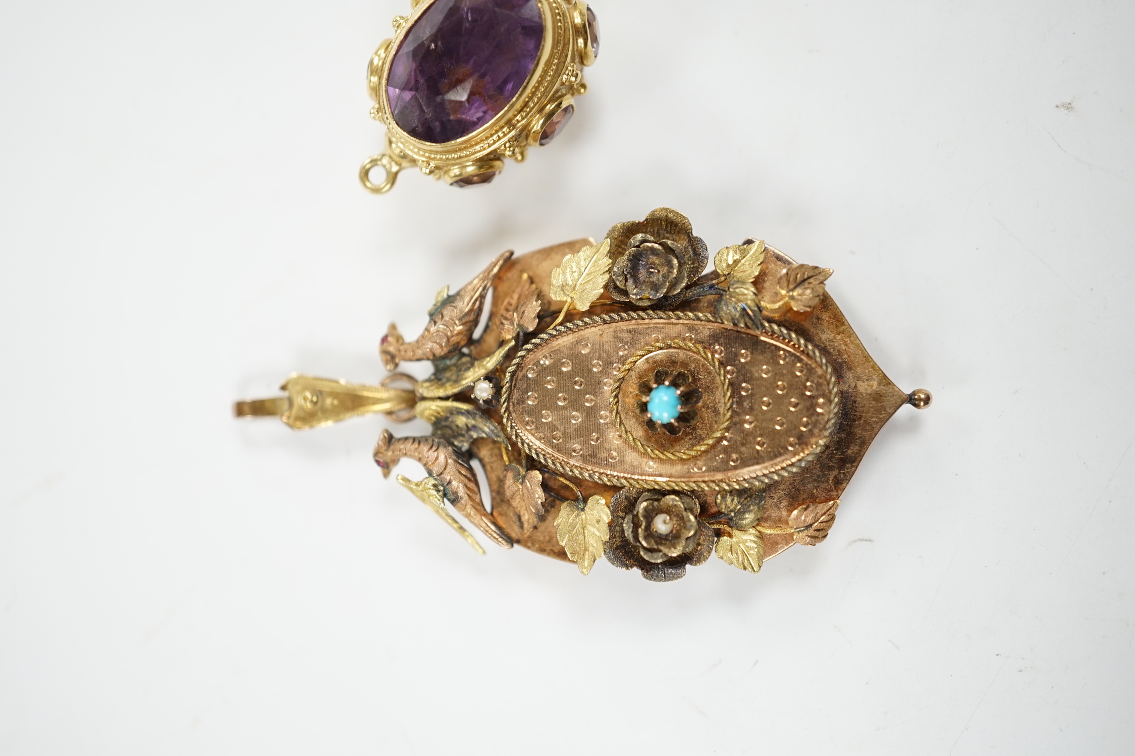 A Victorian three colour yellow metal, turquoise and seed pearl set pendant, decorated with birds and foliage, with glazed back, overall 65mm, together with a yellow metal and eight stone amethyst set charm.